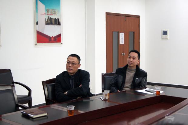 图5、鸿运国际抛光砖销售副总张彦（左一）、鸿运国际广东线销售副总庞永江（右一）认真寓目参评专卖店幻灯片播放效果