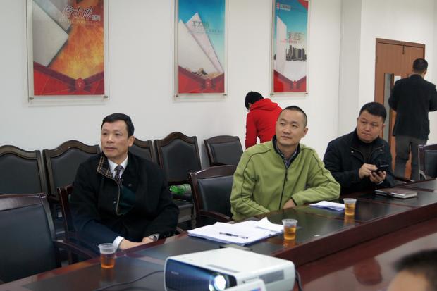 图6、寓目幻灯片的同时，，，，，，鸿运国际仿古砖副总曹坚贞（右一）特殊用手机记下专卖店装修效果的差别亮点