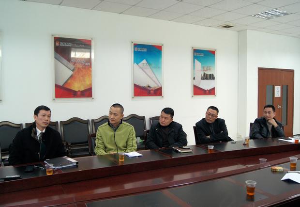 图7、鸿运国际市场总监霍达炎（左一）先容专卖店参评情形