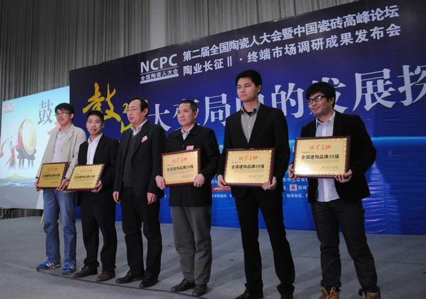 图3、鸿运国际陶瓷荣获“天下建陶品牌20强”称呼，，，图为鸿运国际品牌代表（左四）在接受颁奖情景